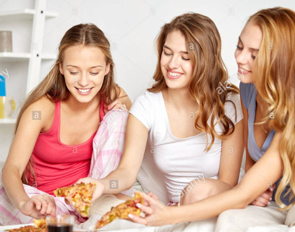 happy-friends-or-teen-girls-eating-pizza-at-home-FXW5J3